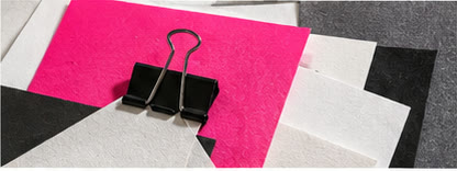 Illustrative collage of vivid paper, a binder clip, and geometric shapes