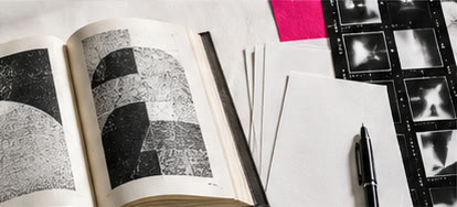 Illustrative collage of an open book, film contact sheets, and a pen
